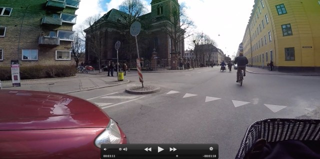 This photo is take from my bicycle handlebars and shows a car holding back to give my bicycle priority in going through this intersection. It's a bit unnerving at first because I'm more accustomed to the car going first.