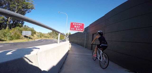 A quirky sign... intended for cars but strangely positioned above the bikeway.